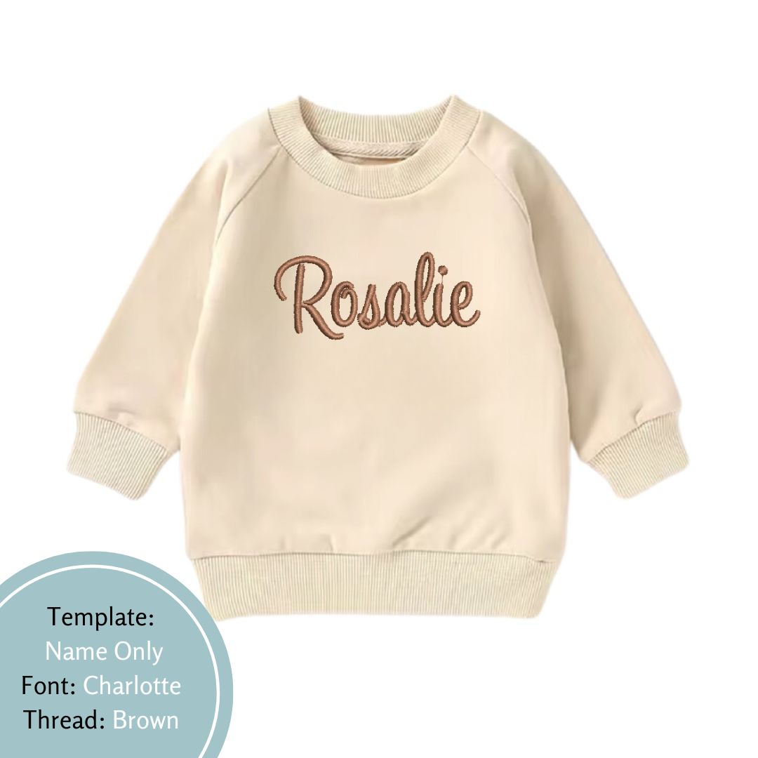 beige baby and toddler crewneck embroidered with a name using brown colour thread
