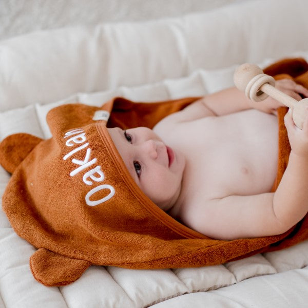 child wearing tan brown hooded bath towel newborn gift personalise with baby name embroidery