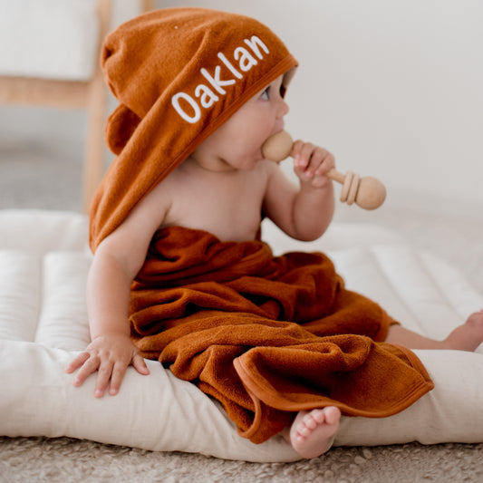 child wearing tan brown hooded bath towel newborn gift personalise with baby name embroidery